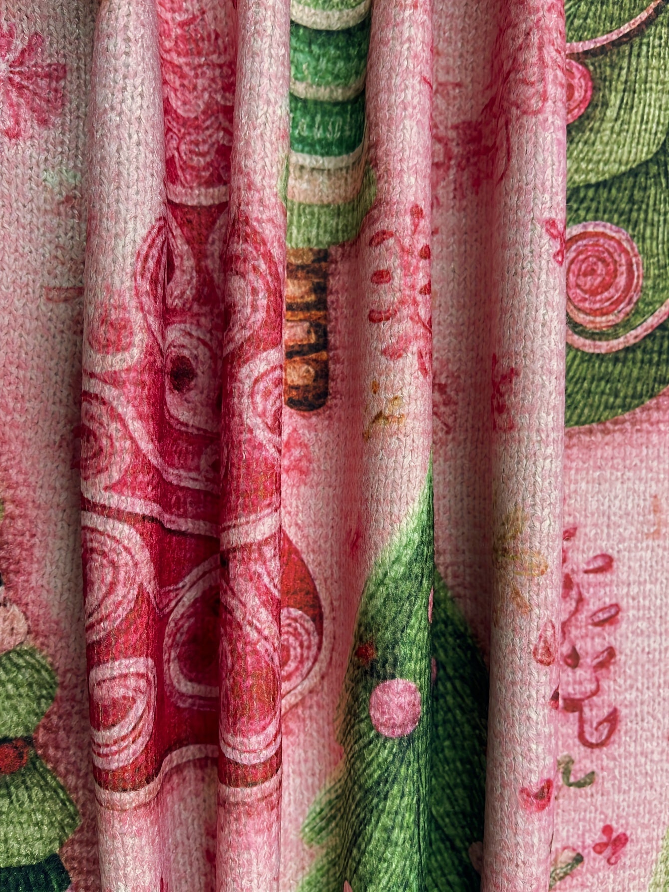 Close-up of a patterned fabric with red, green, and pink colors.